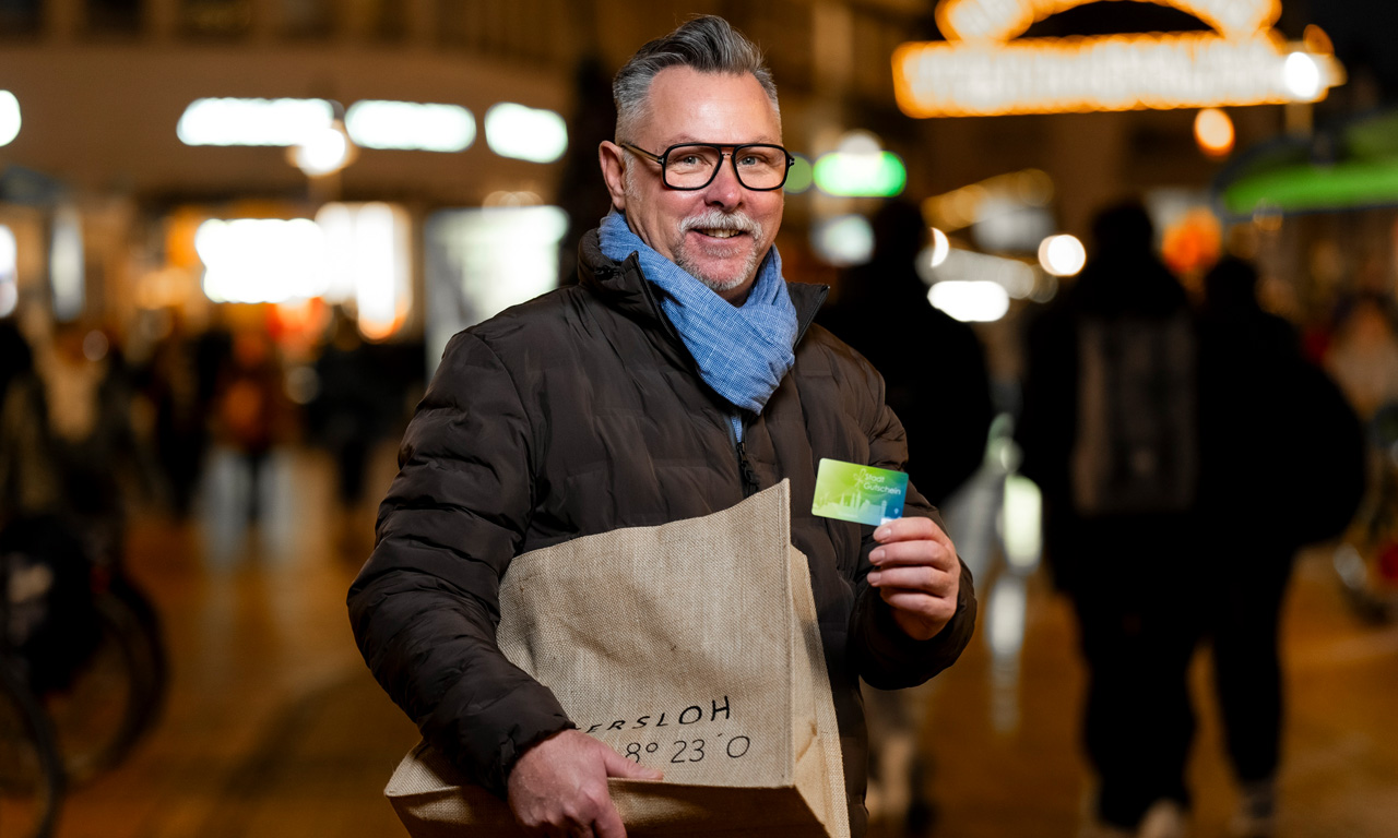 Mann hält Gütersloh Marketing Gutschein