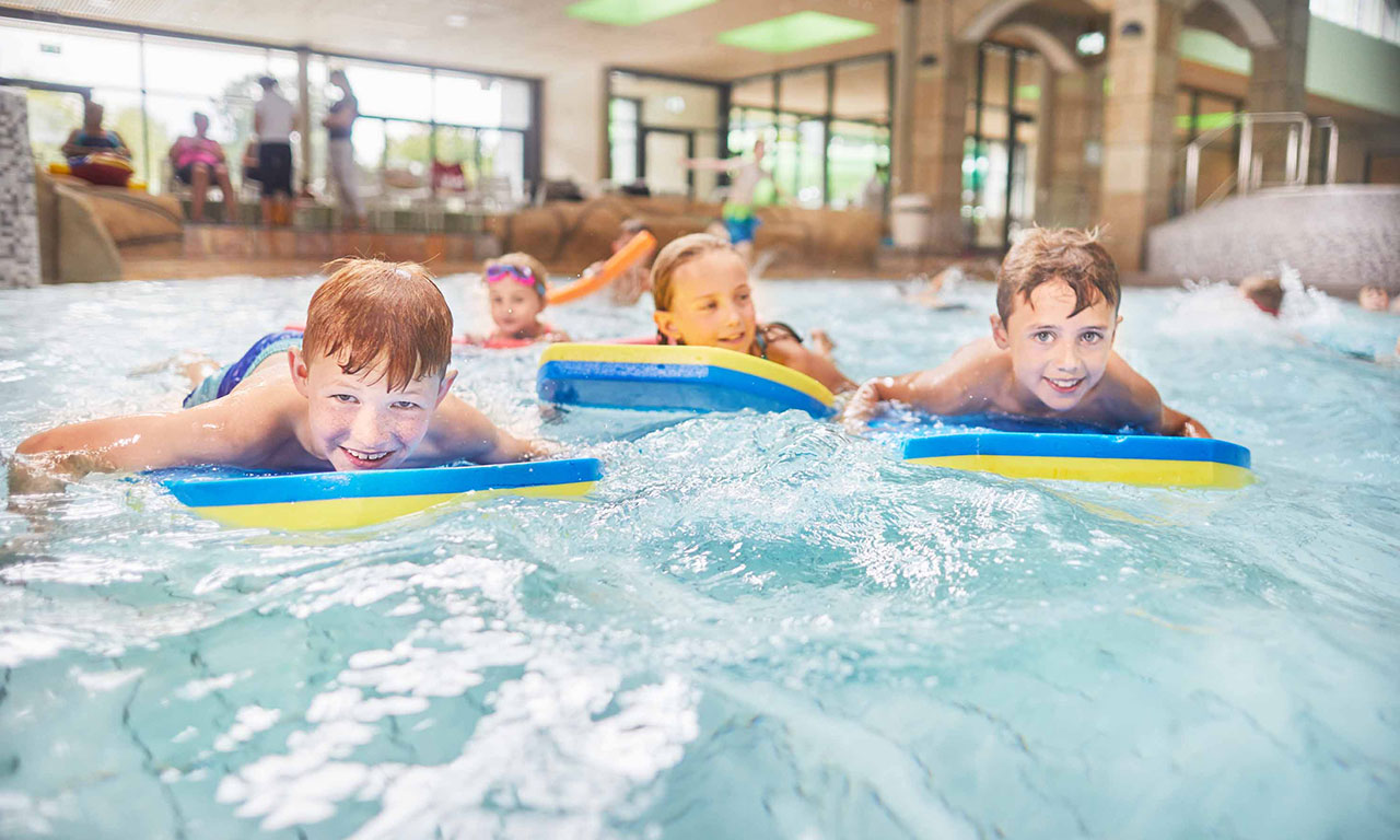 Kinder schwimmen in der Welle Gütersloh